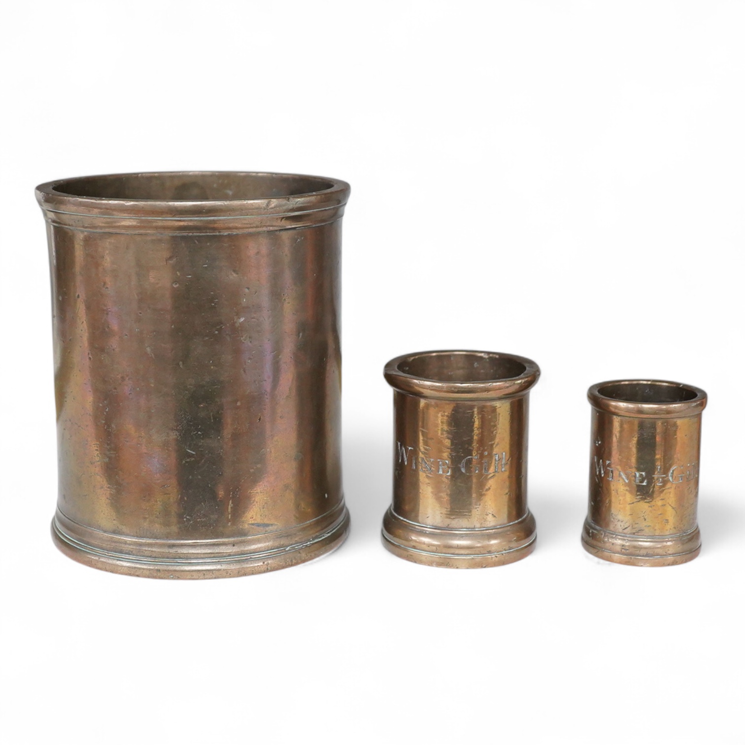 Three 19th century bell metal wine gill measures, two smaller examples engraved; ‘wine hill’, tallest 13.5cm